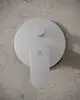 Badearmatur von Ideal Standard mit runder Rosette und einem zentralen Drehgriff für Warm- und Kaltwasserregelung auf einer neutralen Wandoberfläche.